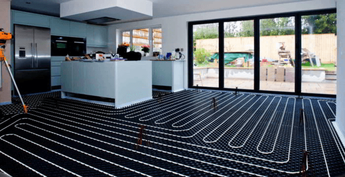 Underfloor heating pipework laid out across a full open-plan kitchen floor before screeding